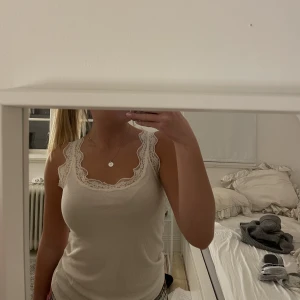 Linne med spets - Ett super gulligt vitt ribbat linne med spets som är båda skönt och fint 