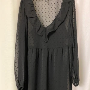 Svart klänning  - Svart kort klänning från H&M. Aldrig använd. Kommer i två delar, en innre linne och själva klänning i spets. 