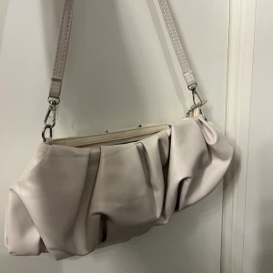 Beige väska  - Denna väska är från SHEIN, den har silvriga detaljer, säljer denna för 45kr!