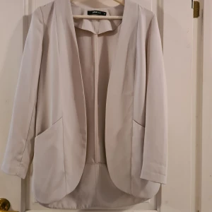 Kavaj Gina Tricot 34 - Beige kavaj/jacka från Gina Tricot i storlek 34 med fickor. Jättefint skick, hittar ingenting att anmärka på.  Frakt tillkommer med 49 kr 🌞