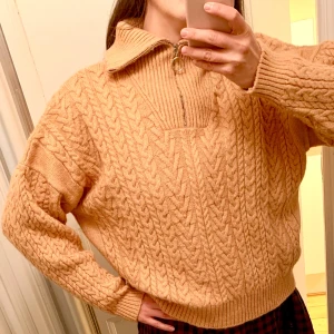 Mysig stickad zipper tröja - Mjukt rosa, något boxig modell med hög krage med dragkedja. Mysig och fluffig! Flätstickad. Lappen är borta, men bedömer som blandmaterial;ull, syntet, viskos. 