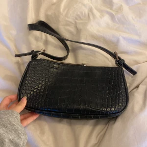 Svart väska - En väska i svart i bra skick från Nelly. Används ej längre.