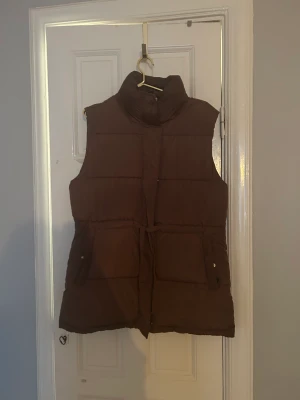 Brun dunväst!  - En brun dunväst från bik bok köpt denna höst/vinter. Priset pga 2 små vita fläckar (syns knappt om man inte kollar noga). Kan frakta eller mötas upp i Stockholm, Södermalm. 