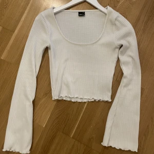 Långärmad vit tröja - Långärmad vit tröja, åtsmitande midja med vida armar i storlek XS.