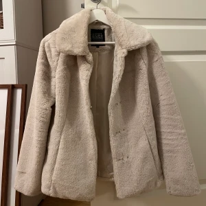 Beige kort pälskappa - Suuperfin ljusbeige kort kappa perfekt nu till vintern och våren! Är i nyskick och använd endast någon gång. Storlek 32/34 eller XS. Skriv vid intresse eller för fler bilder! 🥰