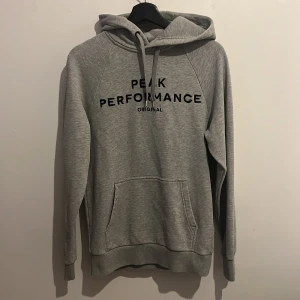 Grå Hoodie  - Säljer nu denna gråa Peak Performance Hoodie i storlek S. Den är knappt använd och i stort sätt nyskick. Nypris 1200kr