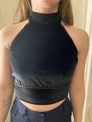 Sammet linne  - Ett svart sammet linne med krage och öppen i ryggen. Köpt för ca ett år sedan, använd en gång. Nypris ca 150kr. Säljer för 75kr. Frakten igår inte i priset 