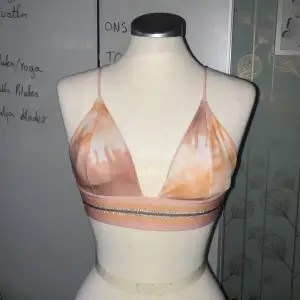 Rosa bikini set med silvriga detaljer på toppen och knyte i sidan av underdelen 