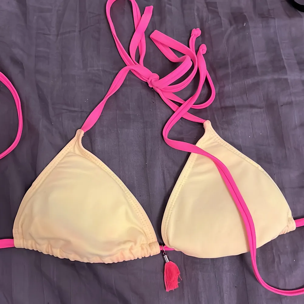 Jättesnygg bikiniöverdel, lite avfärgad på det gula från de rosa snörena som knappt syns när man bär den✨ Köparen står för frakten som är exkluderat från priset✨. Övrigt.