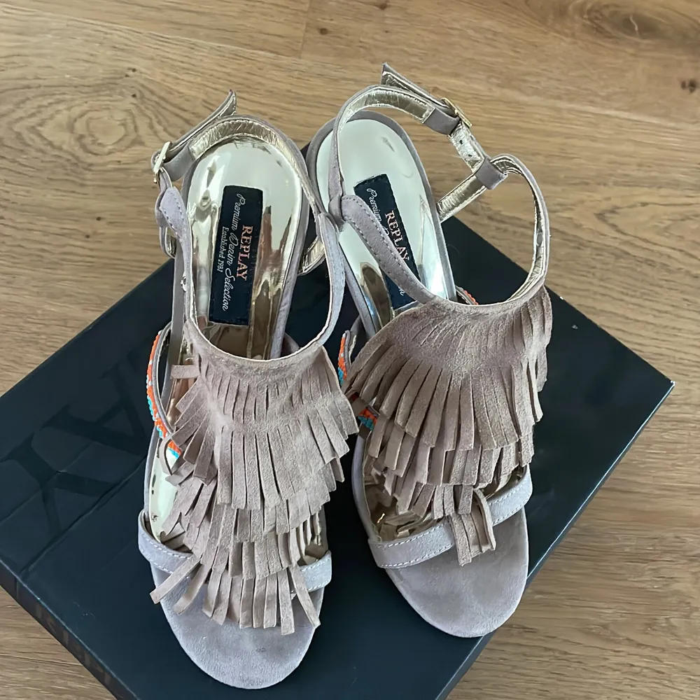 Replay tassel heels, in beige suede with blue and orange embellishments on the straps. Size EU 39. 10cm heel. Worn twice. Very good condition. Comes with original box.. Skor.
