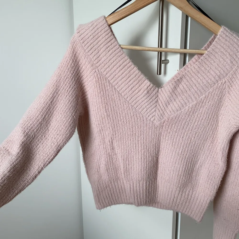 Ljusrosa fluffig, stickad tröja från Divided i storlek S. Superfin djup/bred v-ringning. Lite kortare modell (slutar ungefär vid naveln), med smickrande passform😻. Stickat.