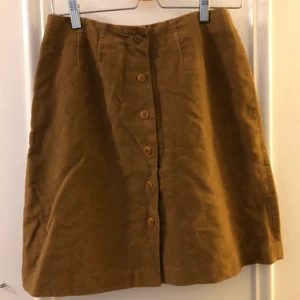 Beige kjol i faux mocka - Fin kjol i mjukt tyg med knappar fram. Ca strlk S-M, skicka DM för mer specifika mått.