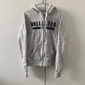 Grå Hollister Ziphoodie - I fint skick. True to size. Vid händerna på mudden finns det som hål för tummarna också! För fler bilder eller mått kontakta mig :)