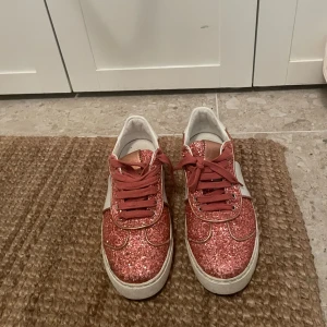 Valentino sneakers  - Säljer mina glittriga valentino sneaker. Har orginalförpackning! Använda ett fåtal gånger vilket syns på sulan under, går att sätta dit nya nitar bak, är creasade fram men inget som stört mig!  Nypris ca 5500