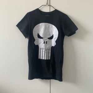 Dödskalle t-shirt - Svart Marvel t-shirt i storlek S. I fint skick förutom ena ärmen som behöver sys ihop från armhålan och ut, vilket jag enkelt hade kunnat göra om inte min symaskin var trasig. Hur som helst, om du äger en symaskin är defekten enkelt och snabbt fixat!