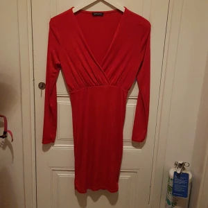 Snygg röd klänning. Julafton? - Så fin klänning med scrunch bak. Tight o formar sig jättesnyggt. Mycket stretch. Lite lyster i tyget. Ser ut som ny. 