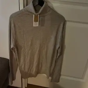 Stilren och basic Jack & Jones polotröja i färgen beige/grå för män, helt oanvänd i strl M och prislappen sitter kvar.