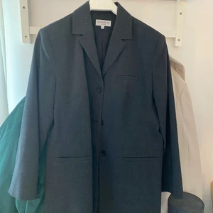 Kavaj - En svart/grå kavaj i strl L. Den passar S också om man vill ha en oversize lång kavaj. Går till låren på mig som är 168cm 