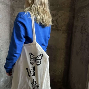 Tygkasse - Säljer dessa stilrena och snygga tygkassar, 100% bomull, naturvit färg med ett svart fjärilstryck. Säljer pga att jag avvecklade mitt UF företag och har nu ett lager över som jag vill bli av med.