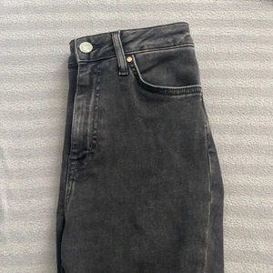 Jeans  - Oanvända svarta jeans med hål i knäna, 