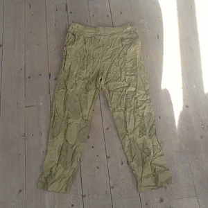 Gula flowy byxor - Ett par sköna sommarbyxor i tunt sidenaktigt material. Raka ben och ganska vida med blommor på (bild 3), färgen är mest som på bild 2.