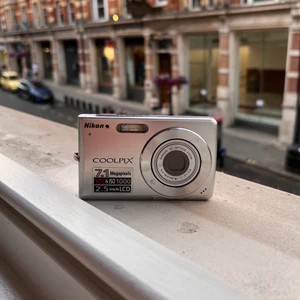 Digitalkamera Nikon - Säljer min älskade Nikon kamera som jag tagit använt omsorgsfullt.   Bilderna är 7.1 megapixels med datumstämpel. De samlas på ett minneskort som enkelt överförs med en adapter (båda ingår). Medföljer även laddare! Köpt på Högdalens andra varvet.