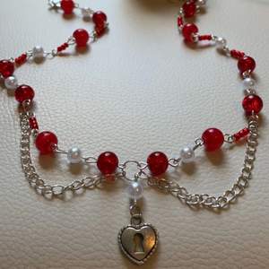 Handmade handgjord halsband i röda nyanser, med pärldetaljer och kedja. köparen betalar frakten