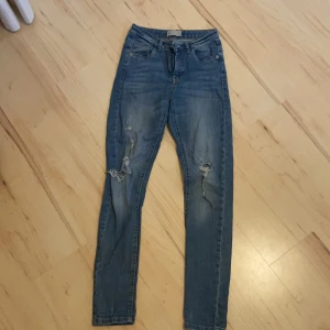 Jeans med slitningar/hål  - Blå jeans med slitningar och håll. Storlek 158