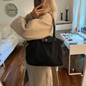 Väska - Väska från dondonna som jag knappt har använt. Väskan är i väldigt bra kvalite då de inte har slitits något på bandet, tyget och dragkedjan. Väldigt lik longchamp väskan. 66kr i frakt som köparen står för💗