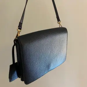 svart väska från h&m med gulddetaljer! två fack och perfekt med plats för fest eller vardag 