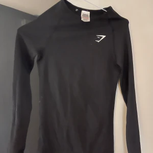 Gymshark träningströja - Använd en gång, tight men strechig i materialet. Färgen är grå/svart 