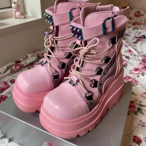 Demonia skor - säljer mina äkta Demonia Shaker 60 pink ankle boots. har använts några få gångar men de har fått en del scratches (bild 3). de är storlek 37 men passar mig som vanligtvis har storlek 38! <3