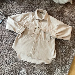 BEIGE KORT KAPPA XS - S - Säljer denna fina höstkappan / jackan. Perfekt med en stickad tröja under. Aldrig använd. Passar på en XS - S. Säljer för 180 kr. Köparen står för frakten! 