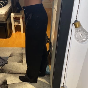 Säljer raka kostymbyxor från madlady - Säljer ett par svarta lågmidjade kostymbyxor från madlady. Det var väldigt svårt att få en rättvis bild på dem. Byxorna har även små knappar på sidorna längst upp vilket gör att man kan justera hur man vill att dem ska sitta i midjan. Passar Xs, S & M