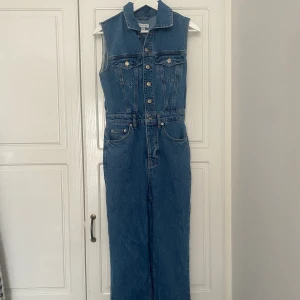 Jeansbyxdress från Topshop - Oanvänd byxdress utan ärmar, knappar på framsidan, ljust blå jeanstyg, storlek S (normal i storleken)