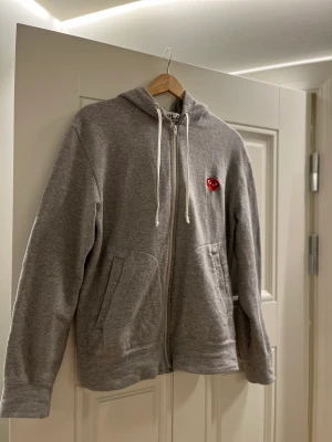 Cdg Zip hoodie - Väldigt bra skick på tröjan bortsett från ett att en sömn gått upp precis vid ens snöret, köpt på Nk Göteborg. Nypris: 3000 kr