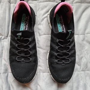Svarta Skechers med memory foam sula. Helt nya. Storlek 36 - Skechers svarta med rosa detaljer och innersula i memory foam. Helt ny inköpta och aldrig använda. Storlek 36. 