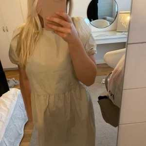 Beige klänning - Fin beige klänning med puffärmar. Den har snörning där bak vilket synd på bild 3. Aldrig använd. 💞💞