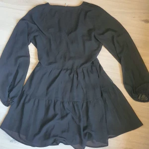 Svart Chiffong omlott volang klänning NLY TREND stl 42 - Fin klänning från NLY Trend stl 42 men passar nog mindre och större då den knyts omlott.  Nyskick!  Obs ! Skickar inte bilder där jag har den på.   Skickar spårbart  Tryck köp nu! Mvh