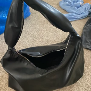 Hm mellanstor väska - Svart ”läder” väska från hm. Helt ny endast använd en gång. Mellanstor modell.