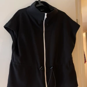 Gina Tricot väst - Mysig väst från Gina Tricot! Perfekt för kyligare sensommarkvällar. Hög krage och rymlig passform. Går att spänna år i midjan.