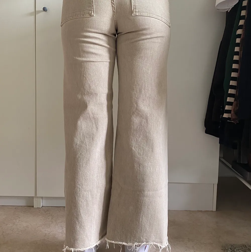 Beiga jeans från Zara. Kortare i modellen med riven kant längst ner. Storlek 36. Använda fåtal gånger, i princip nyskick. Finns nog ej att köpa längre. Köpare står för frakt 🧡. Jeans & Byxor.