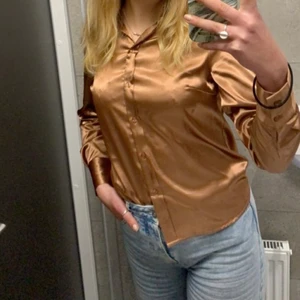 Blus i silke - Kopparfärgad blus i silkesmaterial. I väldigt fint skick! Kolla gärna in mina andra annonser också💫 priser går att diskutera 💛