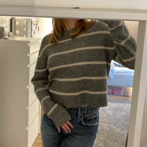 randig stickad tröja från hm - en grå och vit randig stickad tröja ifrån H&M. den är väl använd men i väldigt bra skick💙 perfekt längd och är så snygg till kjolar