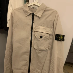 Stone Island overshirt - Storlek: S Fin och välvårdad stone island overshirt, som är i en ljus beige färg. Sparsamt använd och är i skicket 9/10. Seriösa köpare, samt inga byten!