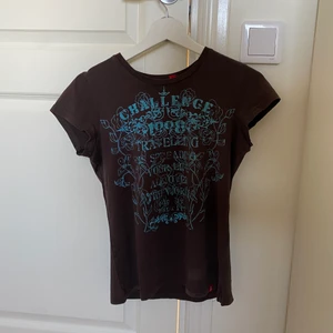 t-shirt  - brun tröja med blå text, säljer få den inte anväds. storlek S. frakt 39kr