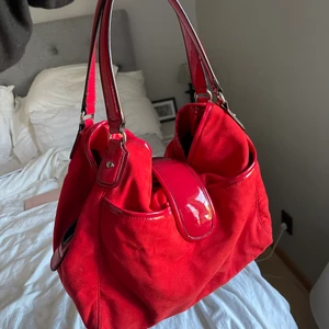 Röd väska - Röd väska köpt på sellpy med 7 stycken olika fack (5 små, två stora, får plats med en dator). Aldrig använd och i gott skick!  Köptes för 200