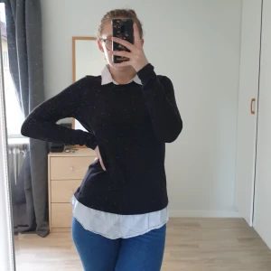 Tröja med skjorta - Tunnt stickad långärmad tröja. Ser ut som det är en skjorta under, men endast tygbitar i kragen och längst ner och blir därmed inte så varmt. Fint skick, använd få gånger.
