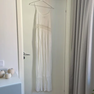 Vit långklänning med virkad spetsmidja - Vit långklänning med virkad spetsmidja, storlek 36. Aldrig använd, prislappen kvar
