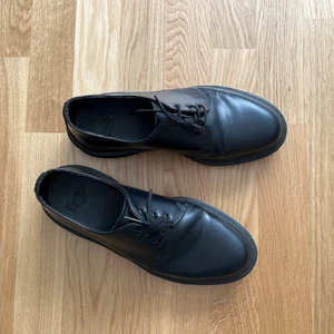 Dr. Martens 1461 Mono Black 41 - Säljer mina martens i storlek 41, impregnerade och har endast använts som finskor därav i superskick! (Ej veganska) Inköpta på Sko UNO för 1 699 kr - säljes för 1 000 kr. Gula snosnören medföljes samt låda!